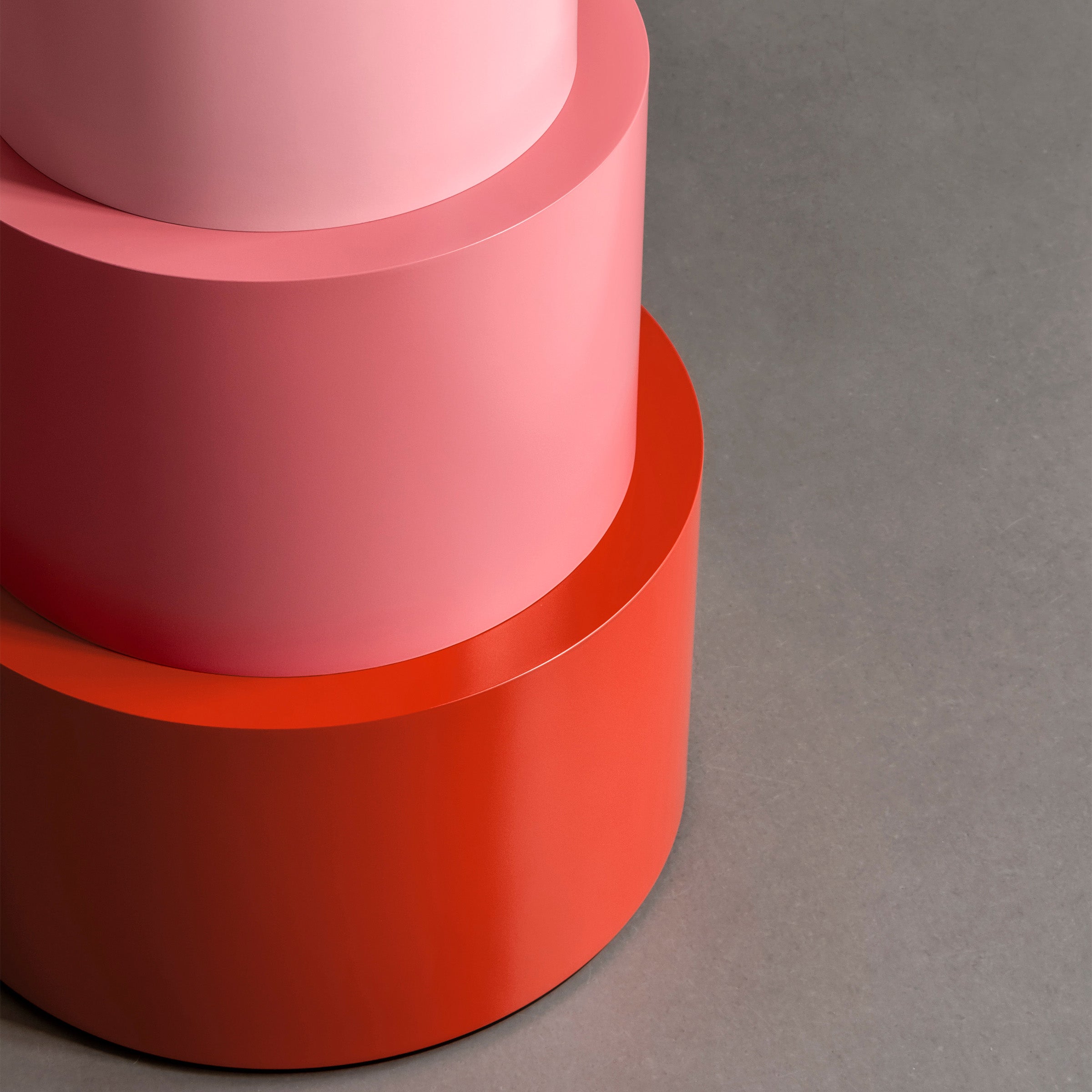 U Turn Table Carrara Marble with three colorful tapered cylindrical base modules on a gray surface.