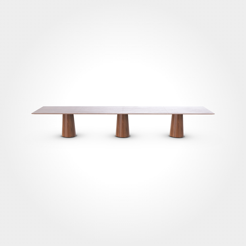 The P.O.V. Plus Table 481 by TON is a sleek, minimalist office and dining table featuring a long rectangular wooden top with a smooth surface, supported by three wide cylindrical legs in a rich brown finish against a white backdrop. Its perfect as a versatile contract and hospitality table.