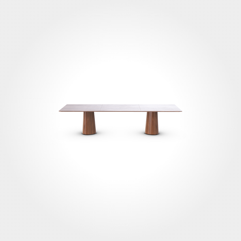 The P.O.V. Plus Table 481 by TON is a minimalist wooden dining table featuring a flat rectangular top and two cylindrical pedestal legs, shown against a plain white background.
