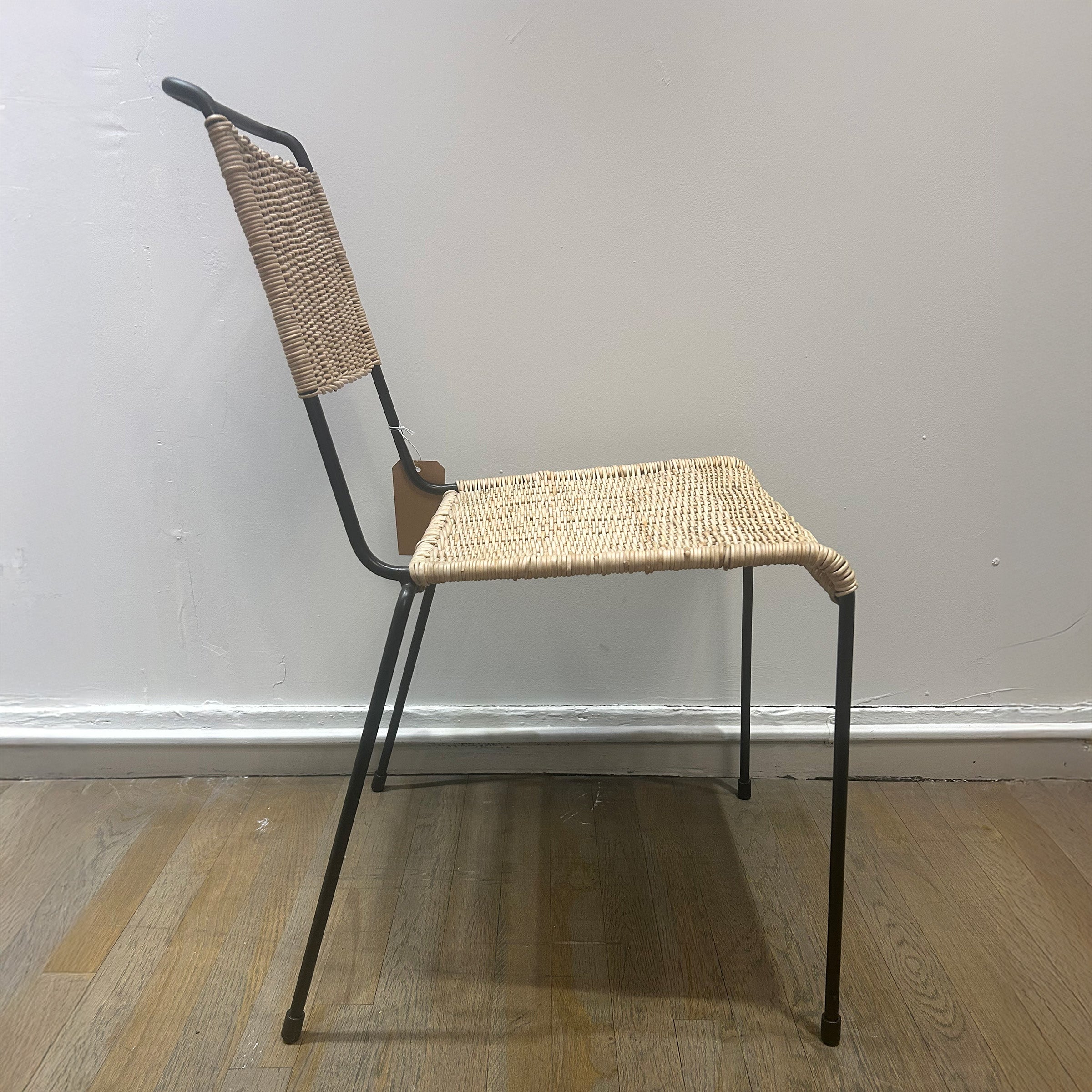 TT54 Rattan - Sale side view of rattan dining chair with steel frame and woven seat and backrest against a plain wall