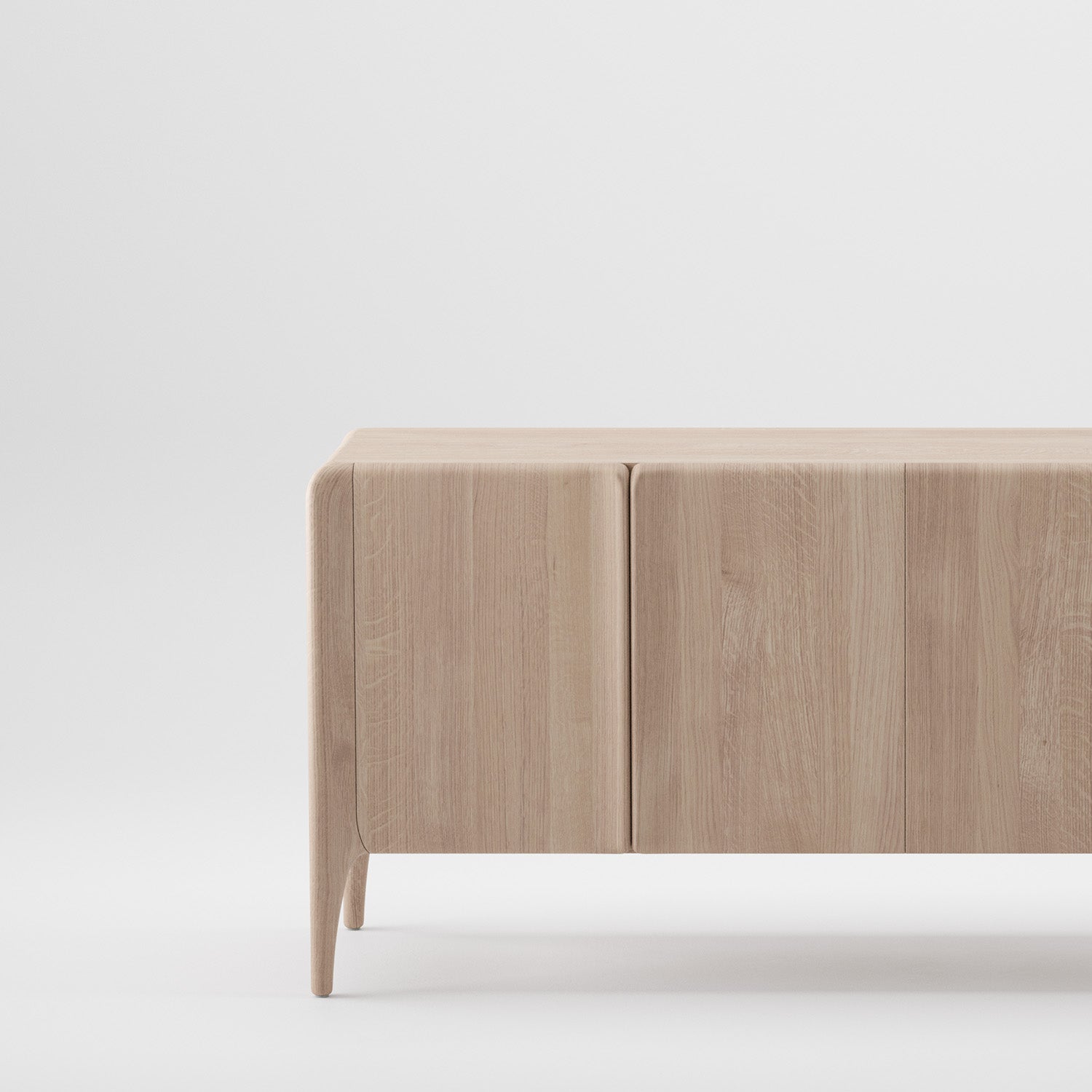 The RIO Sideboard by Artisan is a minimalist piece crafted from solid wood with a light natural finish. It boasts smooth lines, a flat top, and two front panels without visible handles, treated with natural oils and wax.
