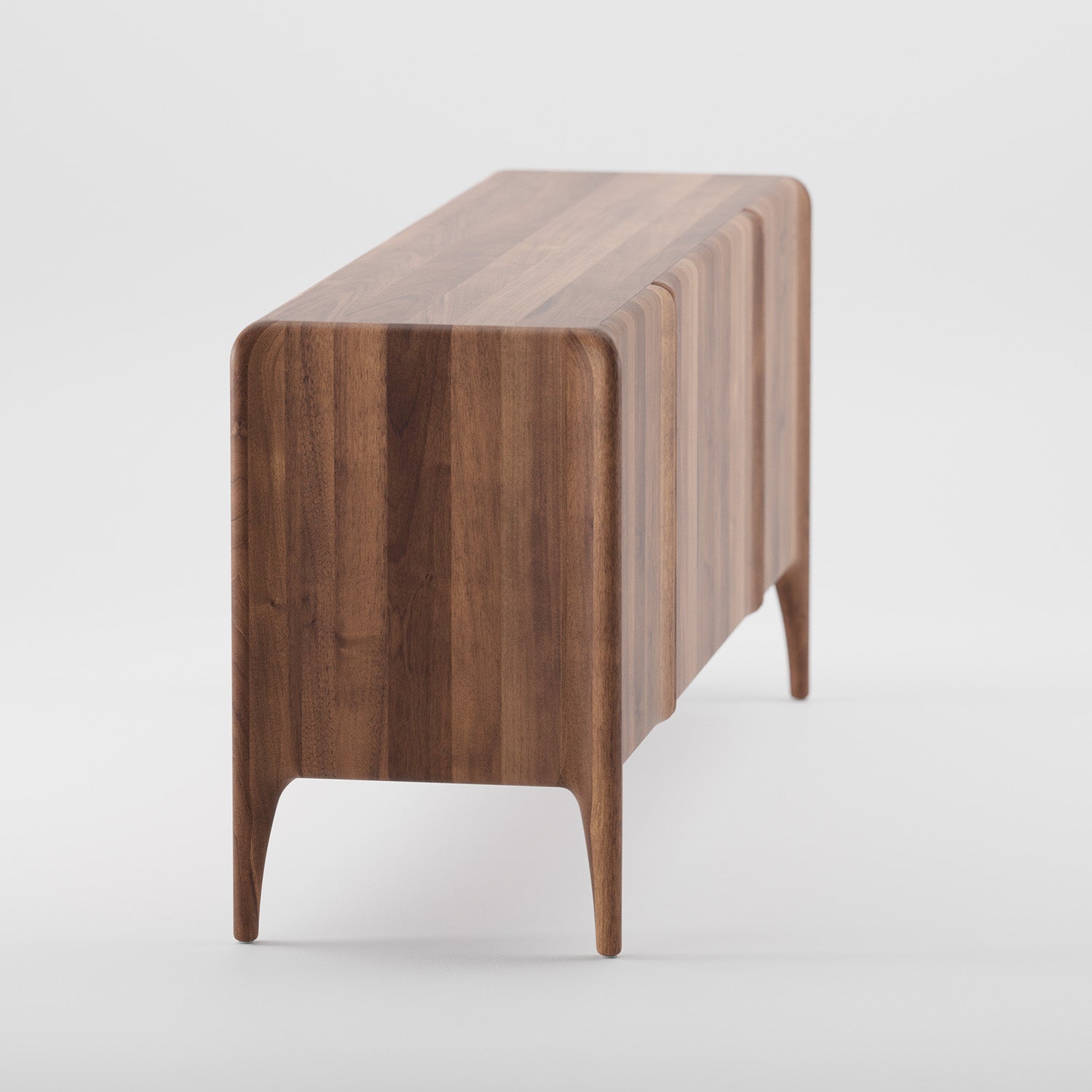 The Artisan RIO Sideboard features a sleek, curved design with four solid wood legs. Its rich natural wood grain is enhanced with natural oils and wax, providing a minimalist style against a plain white background.