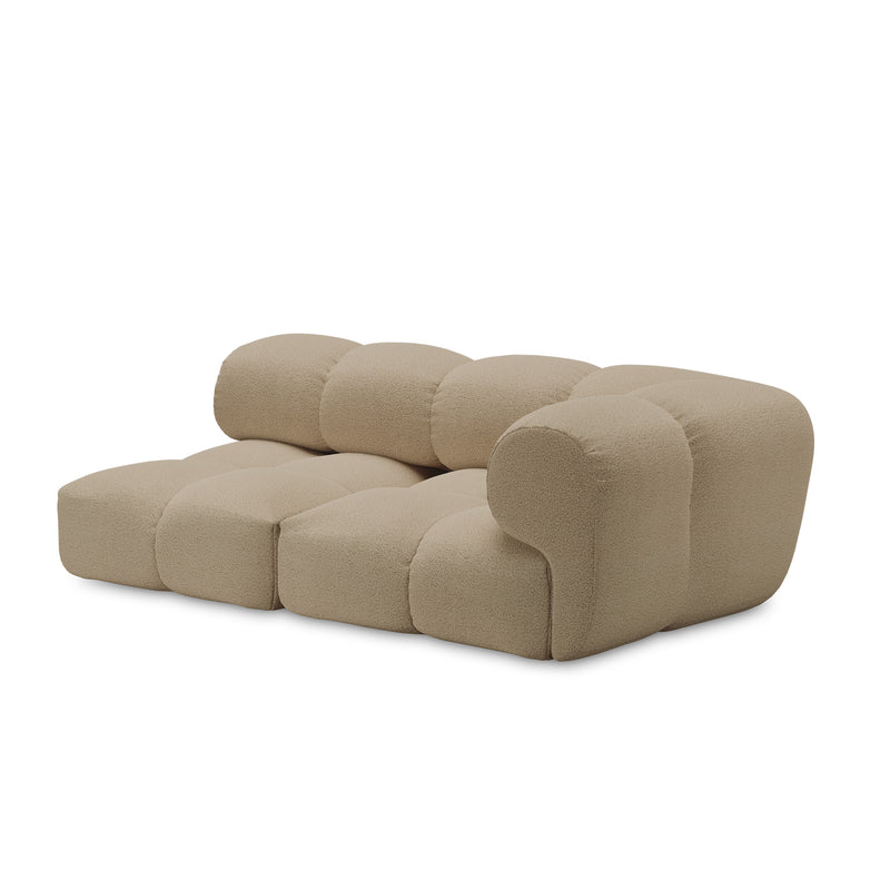 Introducing the Sander Sofa by Objekte unserer Tage: a modern, beige modular three-seater with a rounded, plush design. It features ultrasoft upholstery and a single armrest, embodying contemporary elegance with postmodern flair.