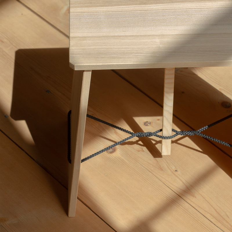 Strammer Max wooden stool by Nils Holger Moormann with plywood panels and black cord detail on wooden floor.