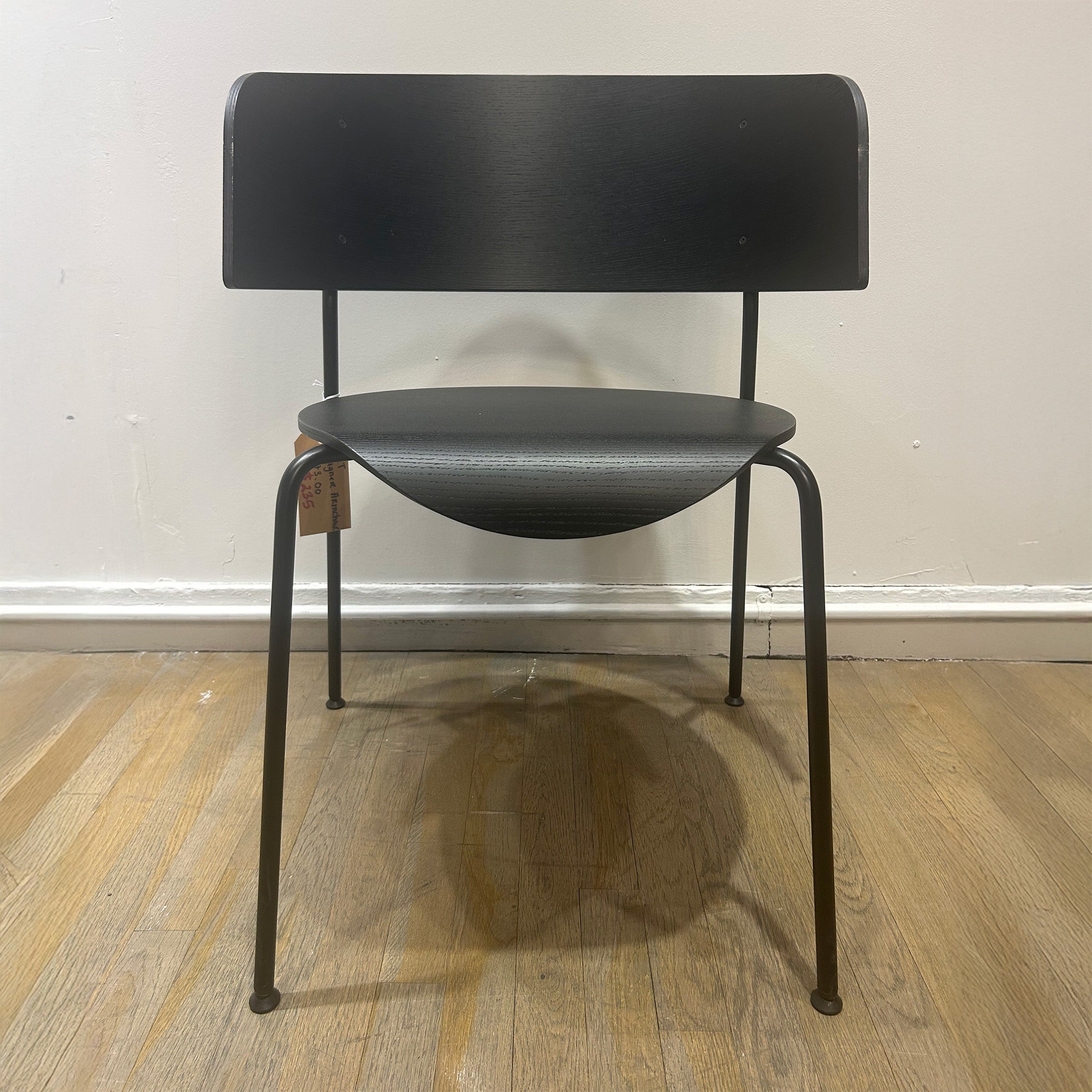 Wagner Dining Chair - Sale black powder-coated steel frame with curved backrest and wooden seat on hardwood floor.