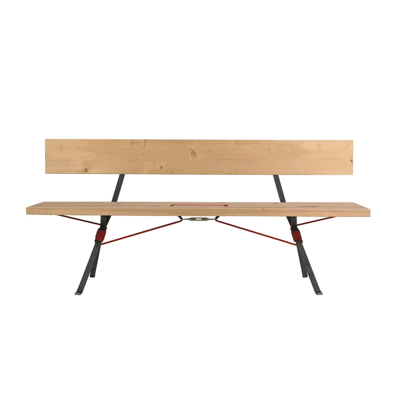 The Kampenwand Bench by Moormann is a minimalist wooden bench with a simple backrest and angled metal legs. Red accents and a central connecting bar complement its modern design, reminiscent of the Nils Holger Moormann style, all set against a plain white background to enhance its sleek aesthetic.