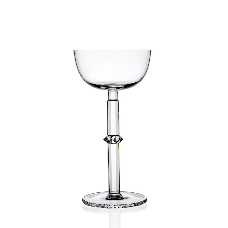 The Hoffmann Goblets by Lobmeyr are clear, elegantly designed champagne glasses made from mouth-blown lead-free crystal. With a tall slender stem and shallow bowl, the base and stem offer subtle decorative details in Josef Hoffmanns style, creating sophistication against a plain white background.