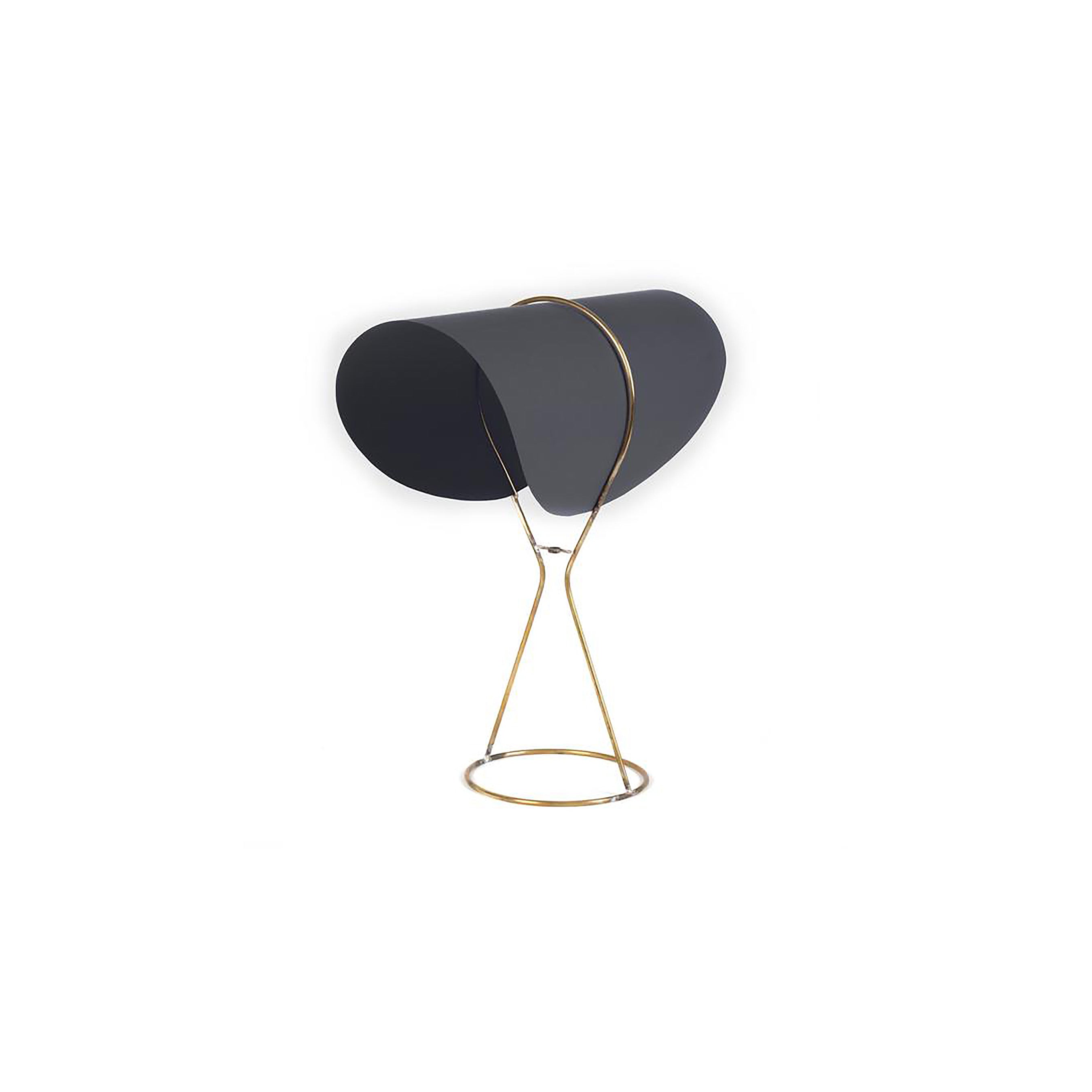 The Table Lamp Nun #4263 by Werkstätte Carl Auböck echoes a chic Viennese design with its unique black drum-shaped shade and elegant gold stand with a looped base, set beautifully against a plain white background.