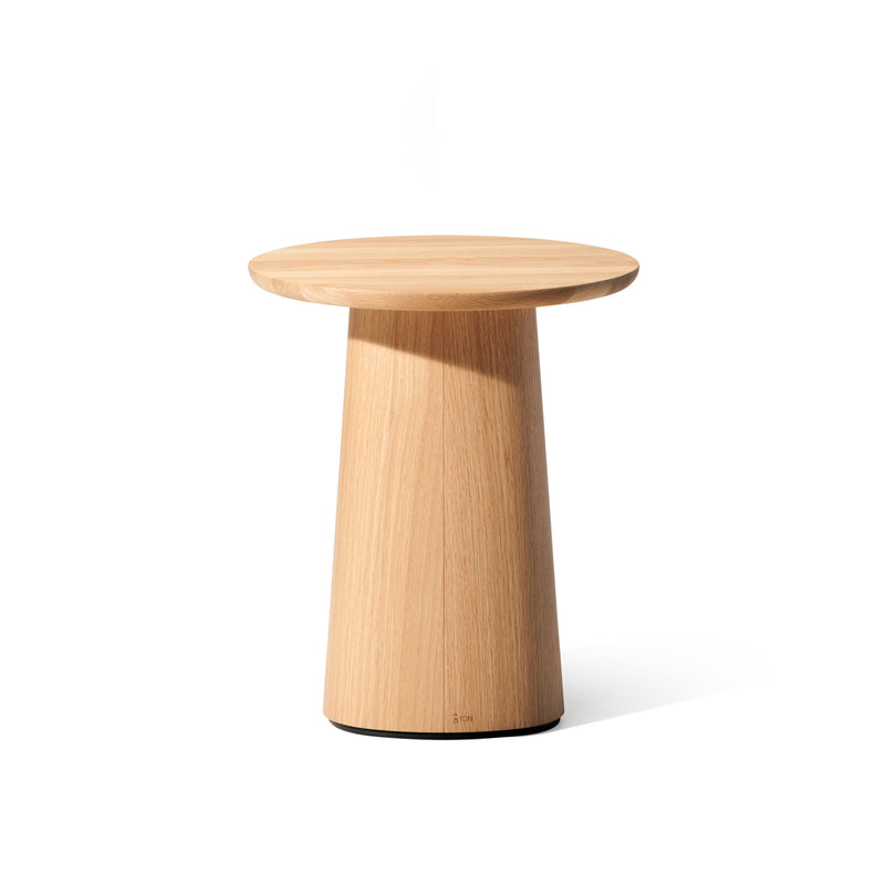 The P.O.V. Coffee Table 473 by TON is a round, light wooden side table with a smooth top and tapered cylindrical base in an organic design against a plain white background. This versatile piece complements various color finishes, ideal as a compact coffee table.