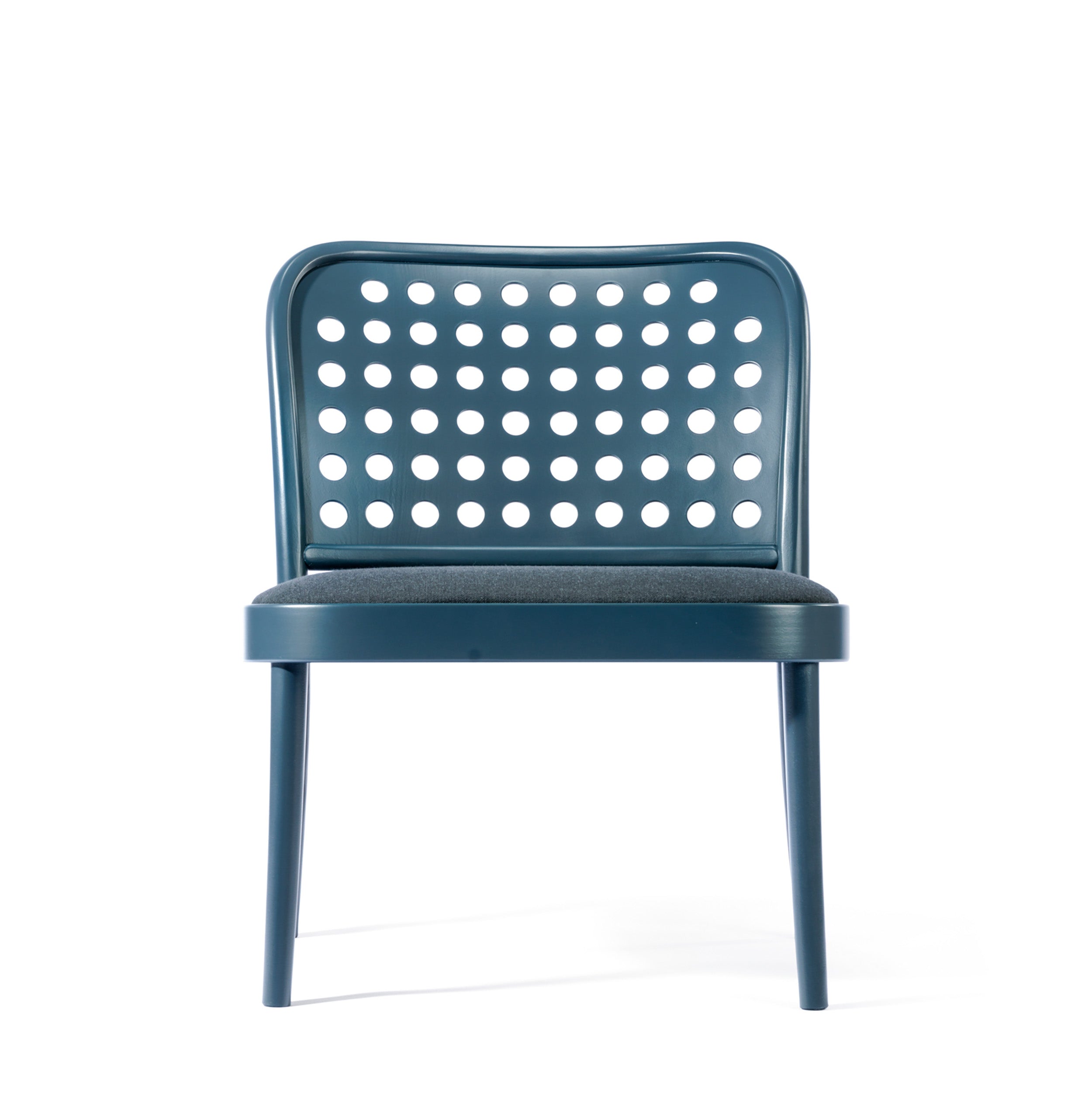 The Lounge Chair 822 by TON, inspired by Scandinavian minimalism, is a modern blue chair with a rounded perforated backrest featuring circular holes and a cushioned seat supported by four straight legs, beautifully captured against a white background.