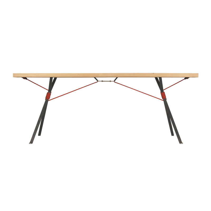 The Moormann Kampenwand Table features a minimalist design with a slim wooden top and angled metal legs, supported by red tension cables. Its modern style highlights the harmonious blend of wood and metal materials.