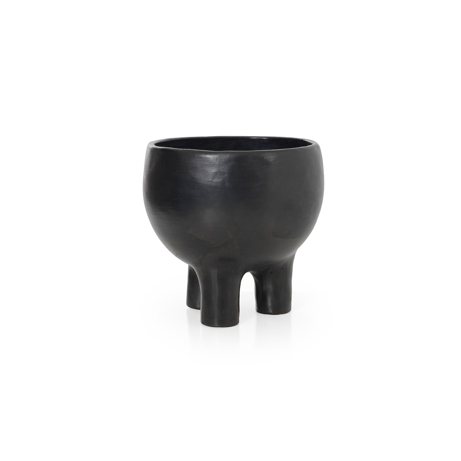 The Barro Pot 2 by Ames features a black matte finish and sculptural three-legged design. Sitting against a white background, its wide rounded body showcases Colombian potterys artistry and modern simplicity.
