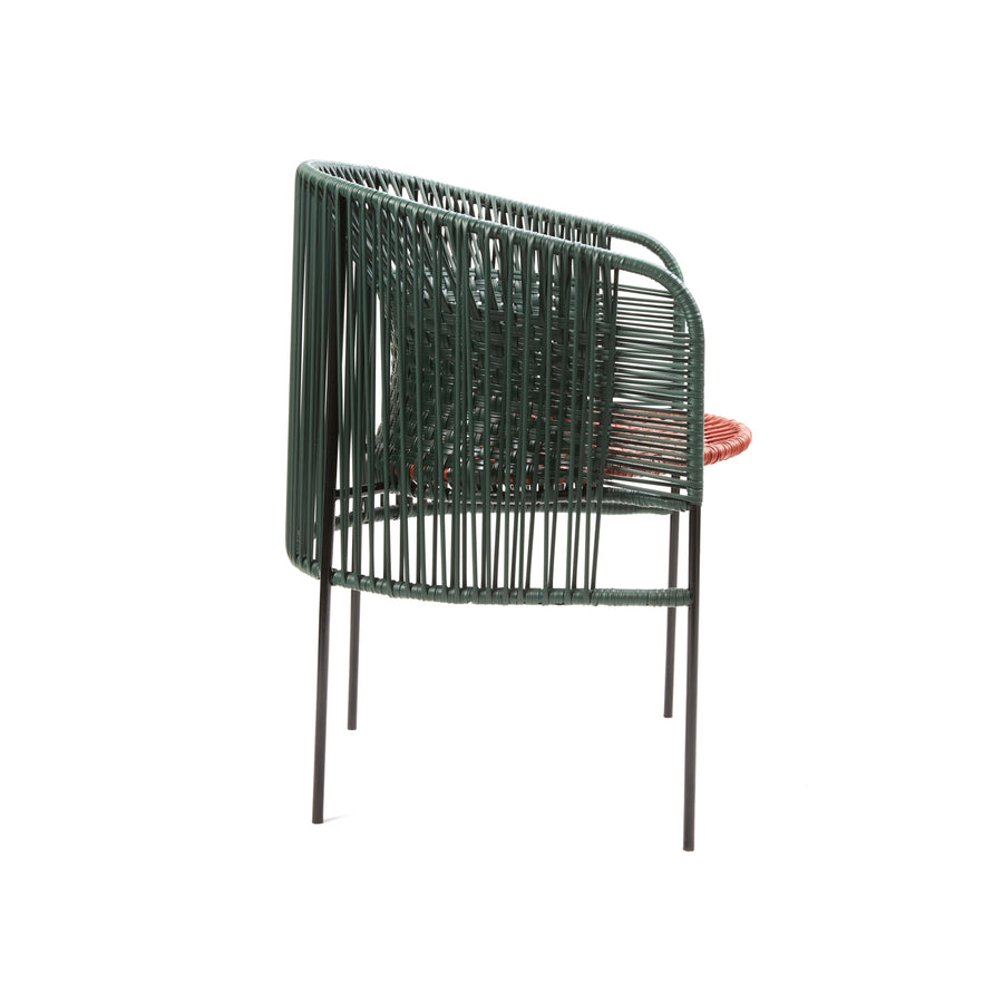 Side view of the Ames Caribe Chic Dining Chair by Sebastian Herkner, featuring a tubular metal frame with recycled plastic cord backrest and seat in green and red, supported by four slender black legs. Its minimalist design is effortlessly contemporary.