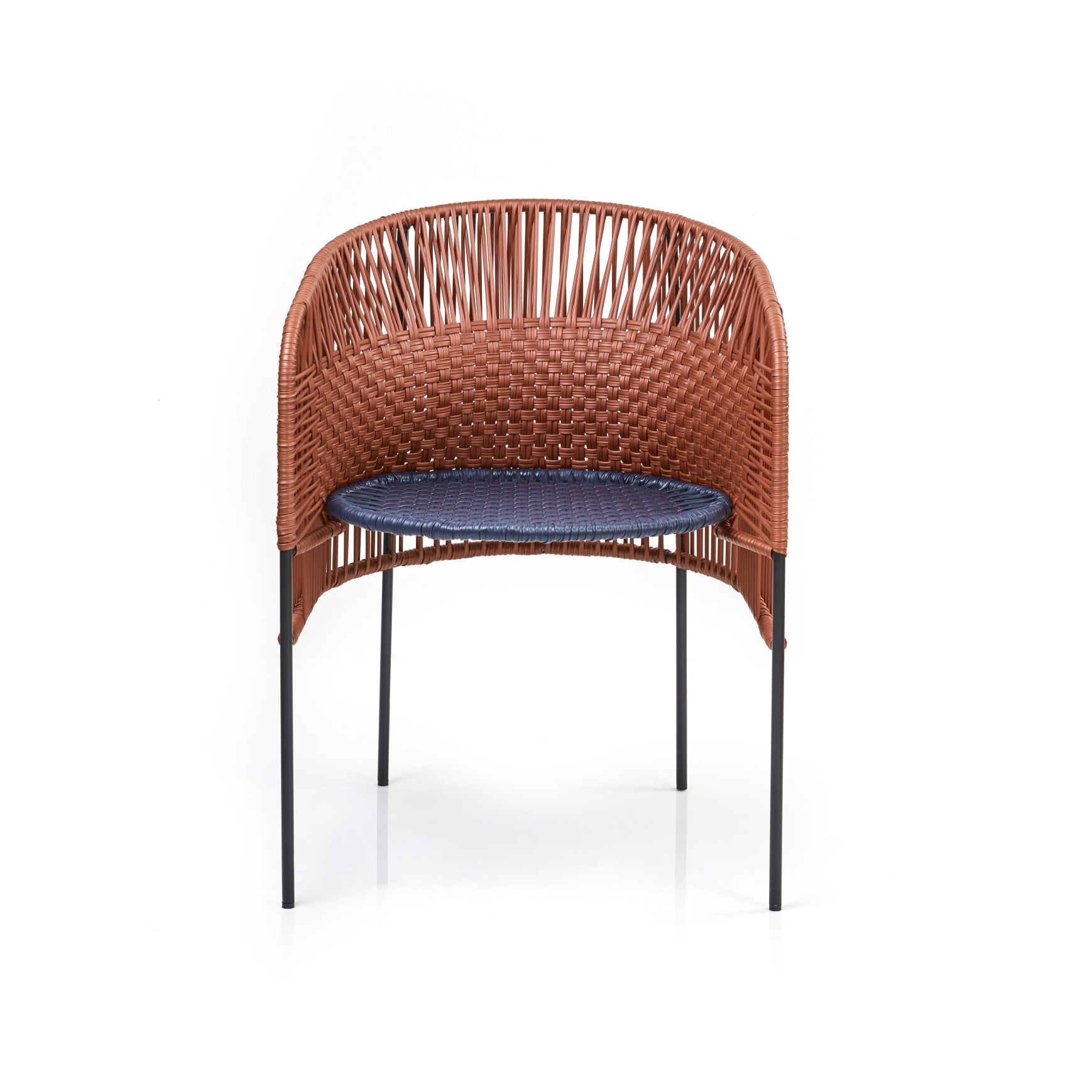 The Caribe Chic Dining Chair from Ames by Sebastian Herkner boasts a woven brown rattan backrest and blue cushioned seat. Its slender black metal legs offer support, capturing the vibrant essence of the Colombian Caribbean coast against a white background.