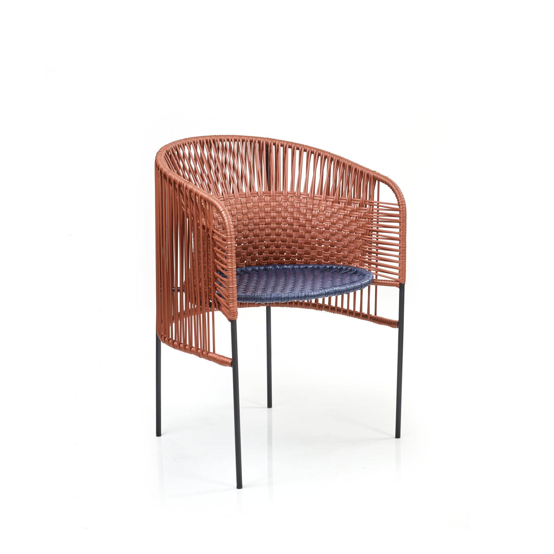 The Caribe Chic Dining Chair by Ames features a rounded brown rattan backrest with a blue cushion, elegantly supported by four slender black metal legs, showcasing modern design infused with Sebastian Herkners creativity.