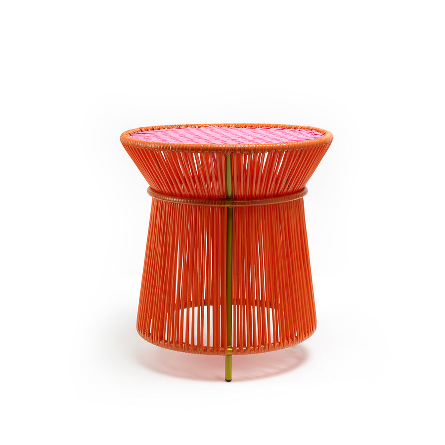 The Ames Caribe High Table by Ames features an hourglass silhouette with a metal frame wrapped in vibrant orange string and a pink woven top, making it a stylish addition to any outdoor space.