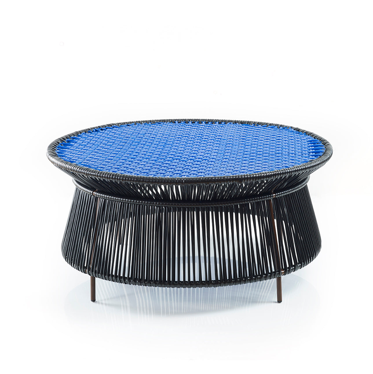 The Ames Caribe Low Table by Ames features a woven black base of thin rods and a flat, bright blue woven top—an eye-catching outdoor piece, inspired by Sebastian Herkner's Caribe Collection and set against a white background.