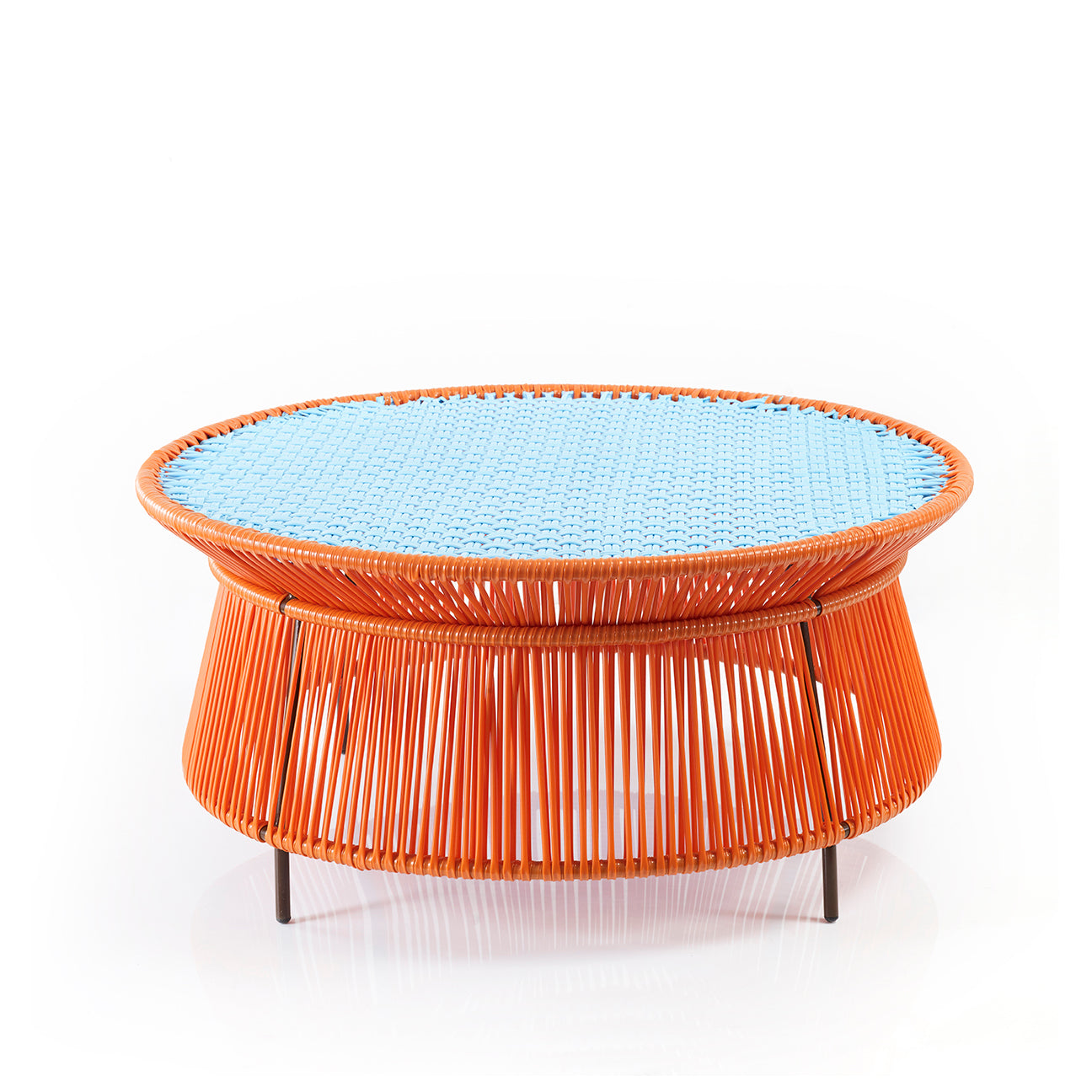 The Ames Caribe Low Table by Ames, designed by Sebastian Herkner, features an orange woven wicker base, a flat blue top, and short black metal legs—making it a vibrant statement piece for any outdoor setting.