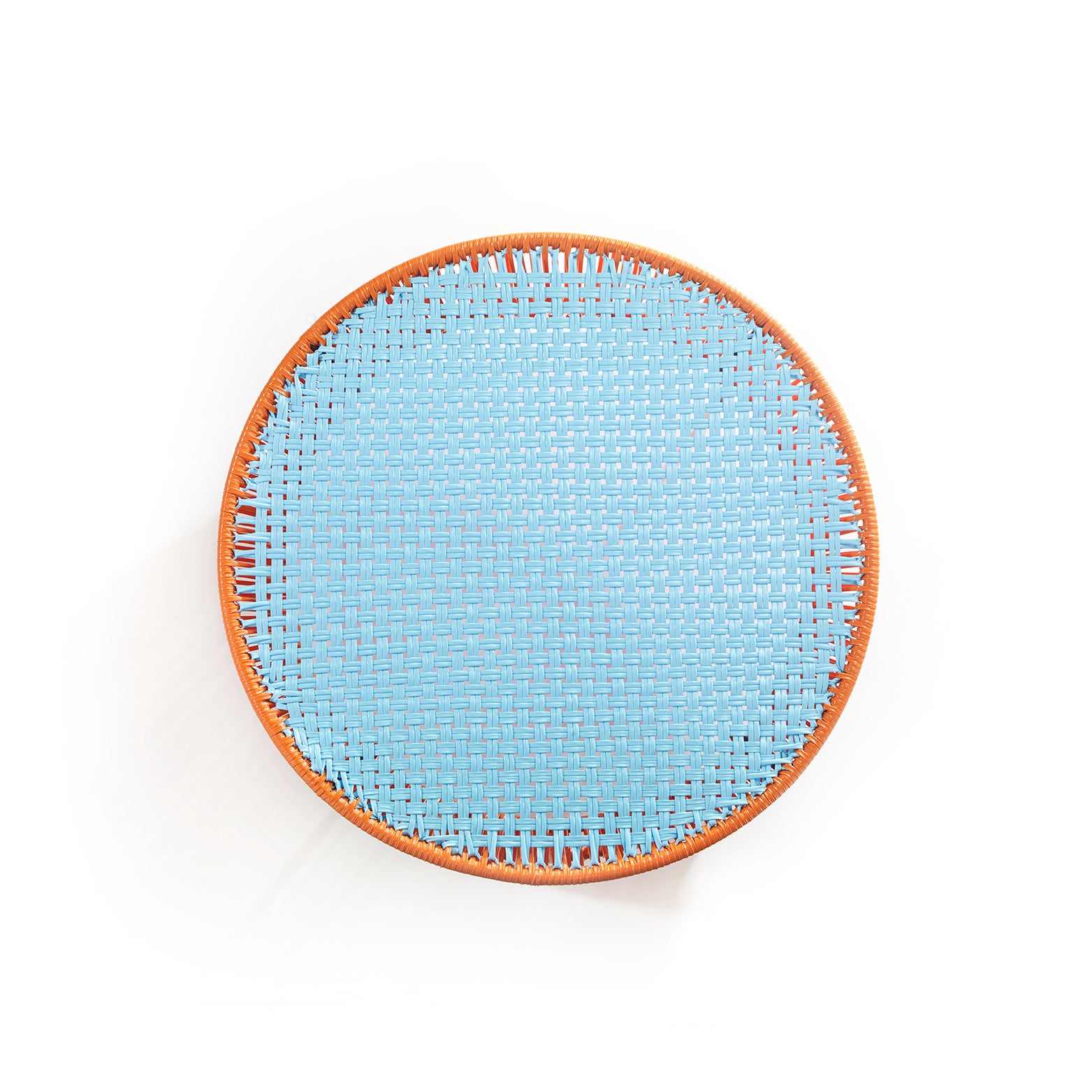 The Ames Caribe Low Table by Ames, designed by Sebastian Herkner, boasts a round woven design with a light blue center and brown rim—an ideal accent for outdoor furniture, shown from above against a white background.