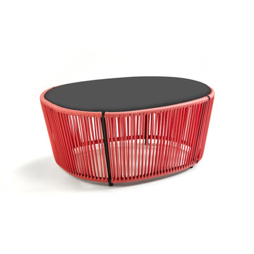 The Ames Cartagenas Coffee Table by Ames has a black oval top and a red open-frame base of vertical rods, designed by Sebastian Herkner, shown against a white background.