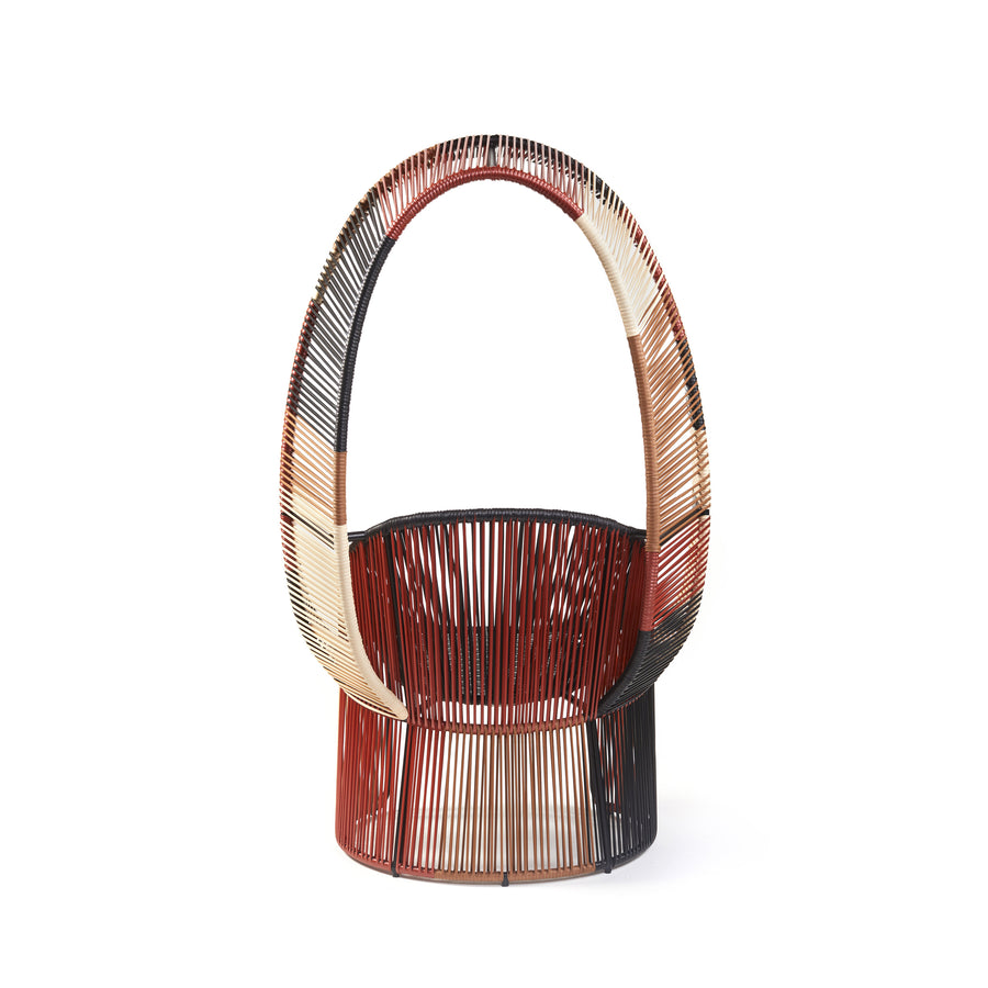 Introducing the Cartagenas Reina Chair Limited Edition by Ames, a modern masterpiece with an arched backrest in woven shades of red, cream, and black. Its circular base and airy structure add artistic flair to any outdoor space.