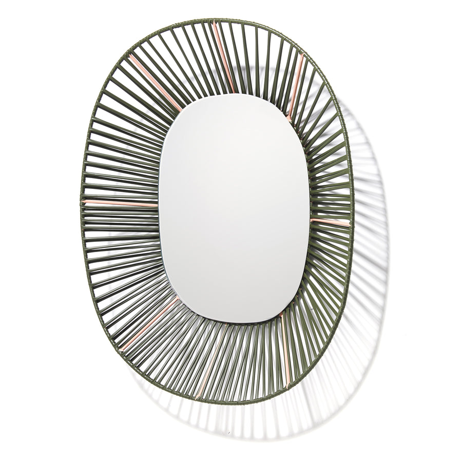 The Cesta Mirror by Ames is an oval wall mirror with a distinctive wire frame that forms a detailed sunburst pattern. Evenly spaced metal wires cast intricate shadows on a white background, enhancing its artistic flair and making it a standout piece with vibrant color combinations.