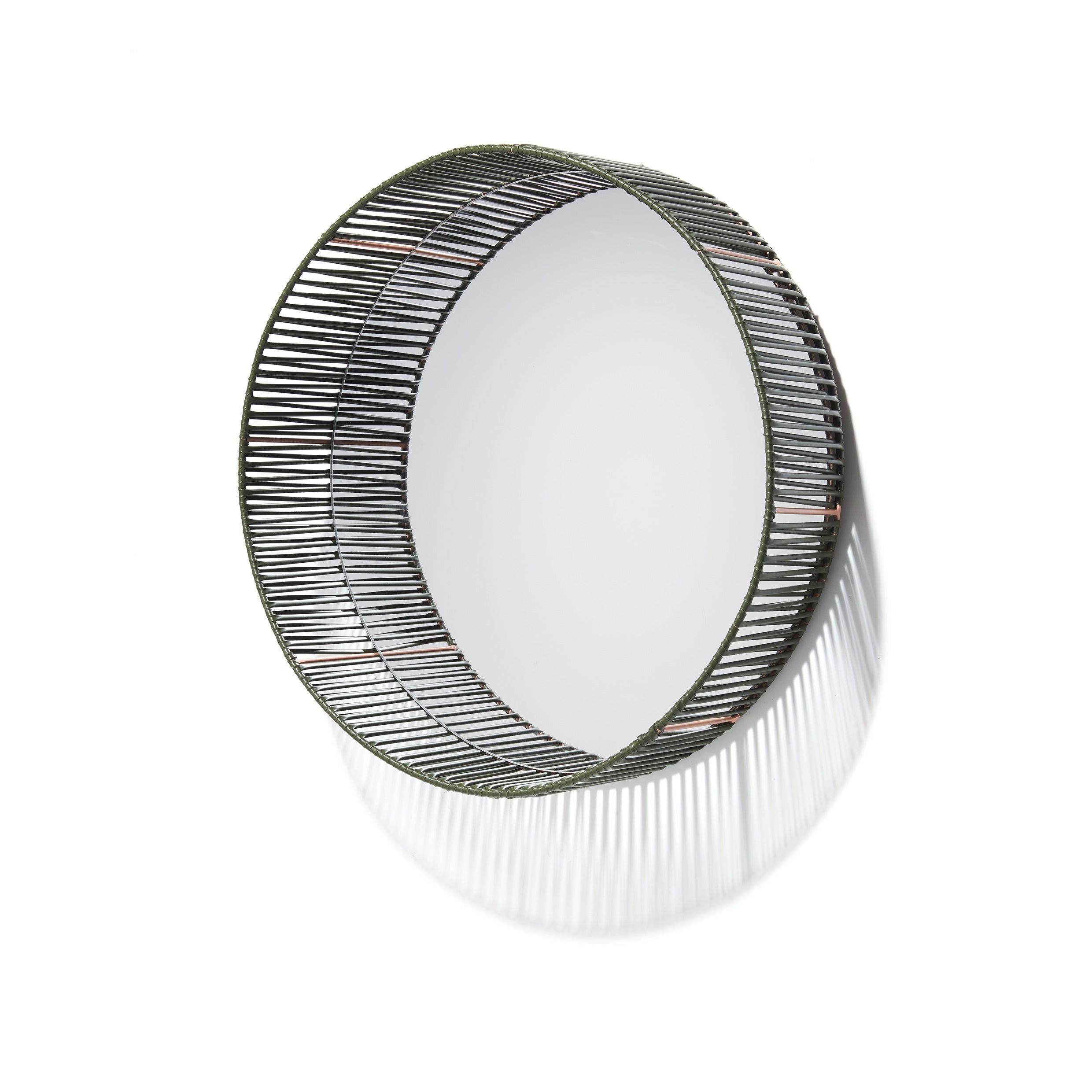 The Cesta Mirror by Ames features a circular design with a decorative black wire frame that projects outward, casting intricate shadow patterns. Its minimalist style and recycled PVC lace enhance modern aesthetics, making it ideal for spaces seeking eco-friendly elegance.