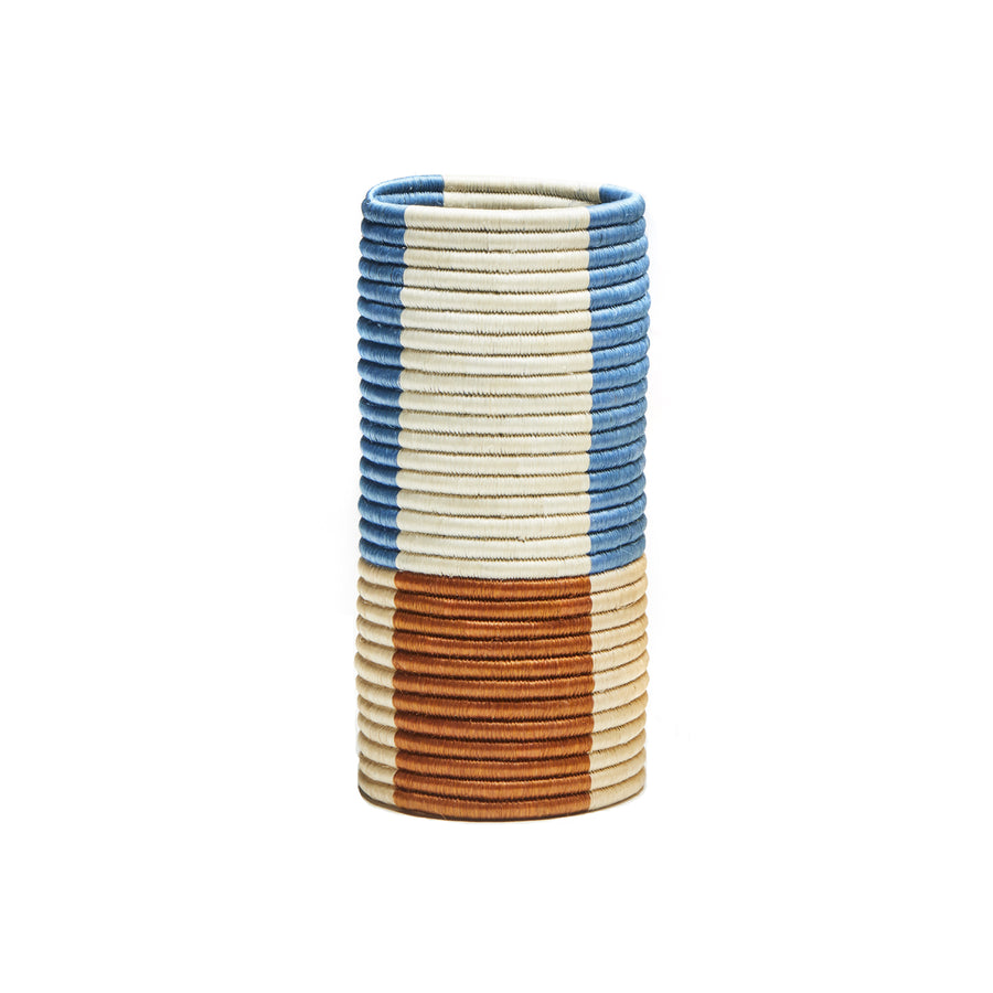 The Choco Vases by Ames feature a cylindrical design with alternating horizontal bands in blue, cream, and rust colors. The textured pattern mimics palm fibers for a uniquely layered appearance.