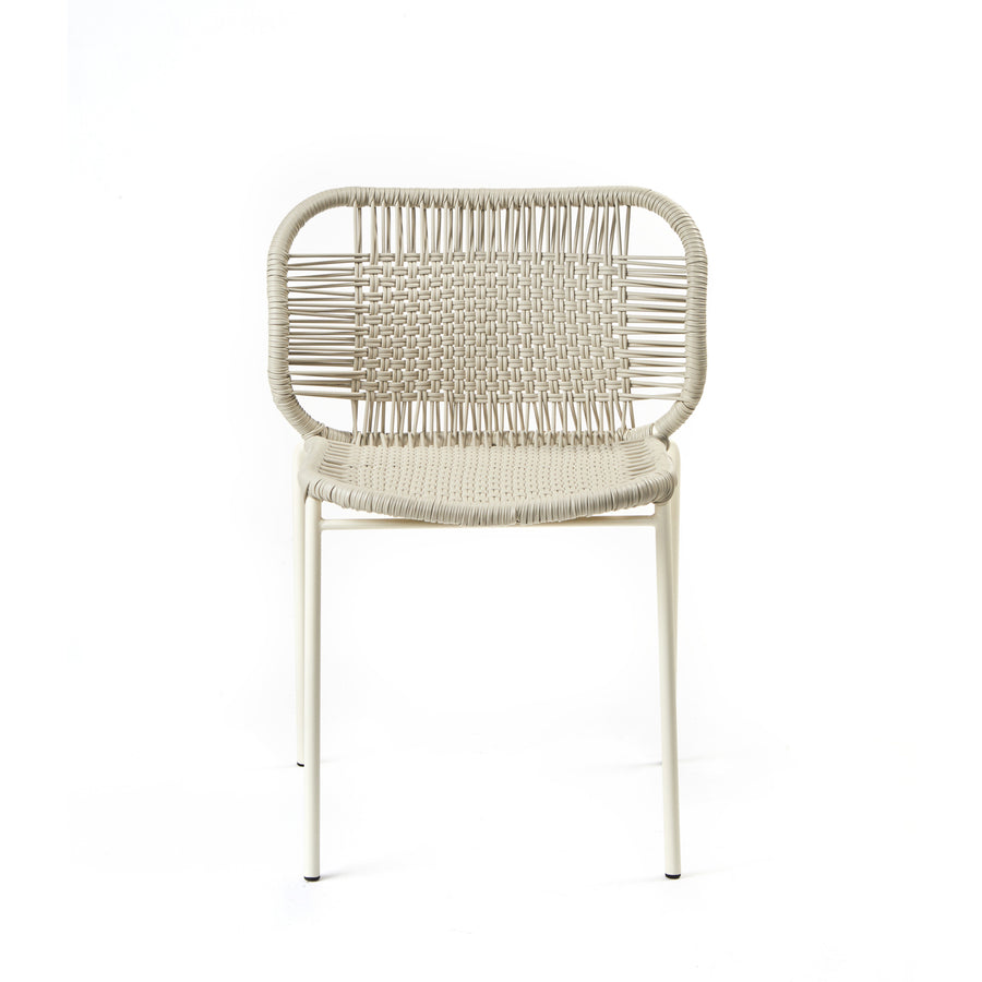 The Ames Cielo Chair by Ames is a modern, stackable outdoor dining chair with a woven rattan seat and backrest, rounded rectangular frame, and slim straight legs in a light neutral tone—ideal for stylish patios or gardens.