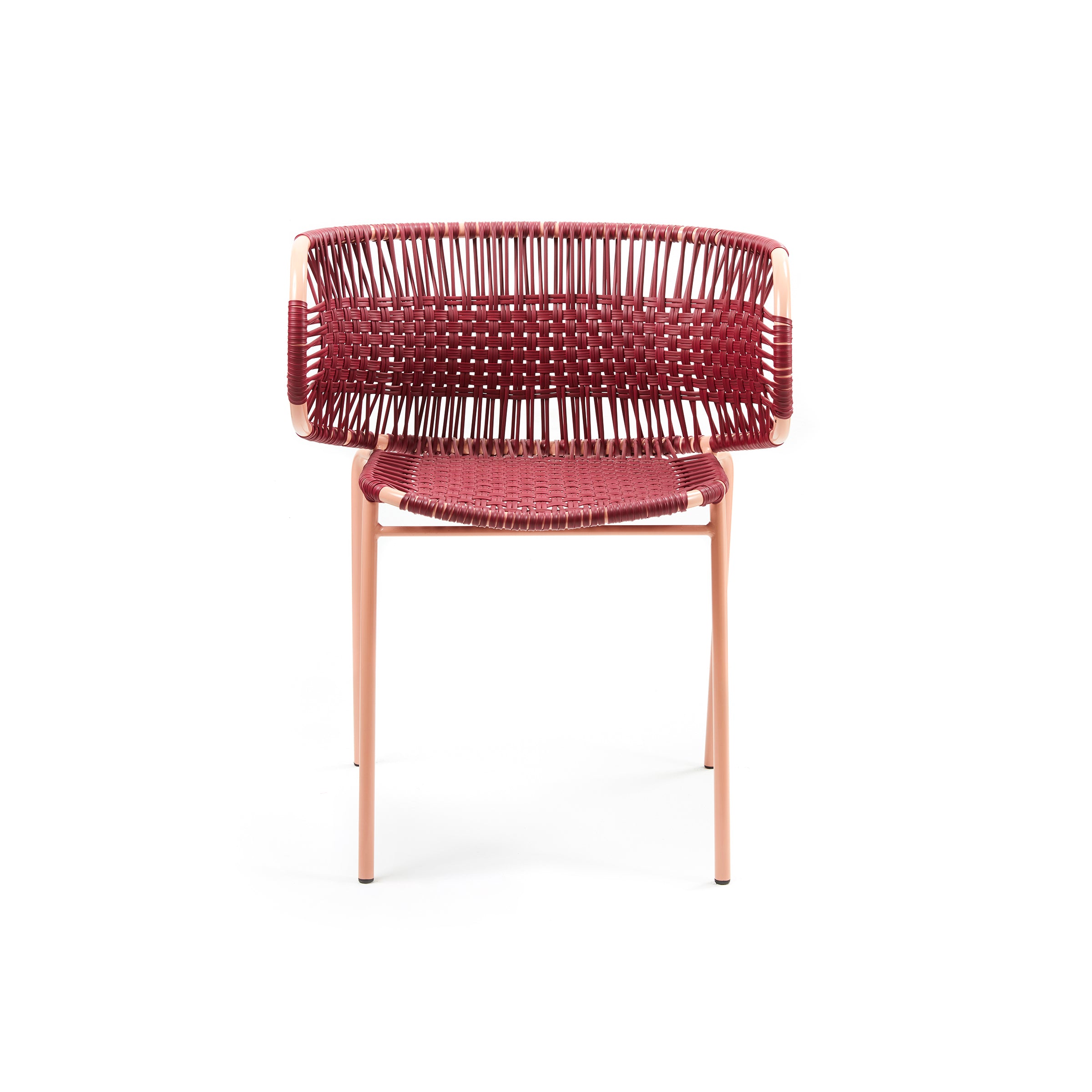 Front view of the Cielo Armchair by Ames, showcasing a woven red seat and backrest. This minimalist piece uses traditional weaving on a light frame with slightly angled legs, ideal for outdoor spaces against a white backdrop.