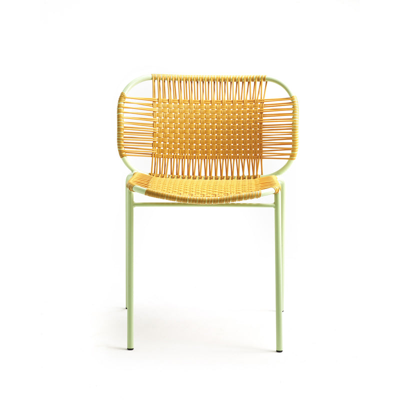 The Ames Cielo Chair by Ames is a modern outdoor dining chair featuring a light green metal frame with woven rattan seat and backrest, shown against a plain white background.