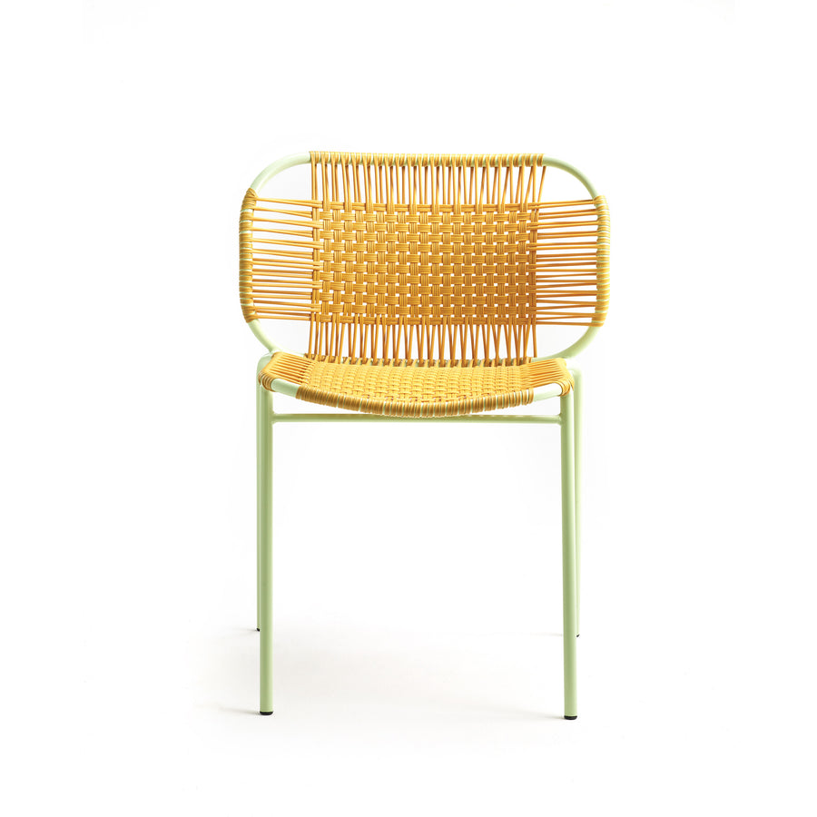 The Ames Cielo Chair by Ames is a modern outdoor dining chair featuring a light green metal frame with woven rattan seat and backrest, shown against a plain white background.