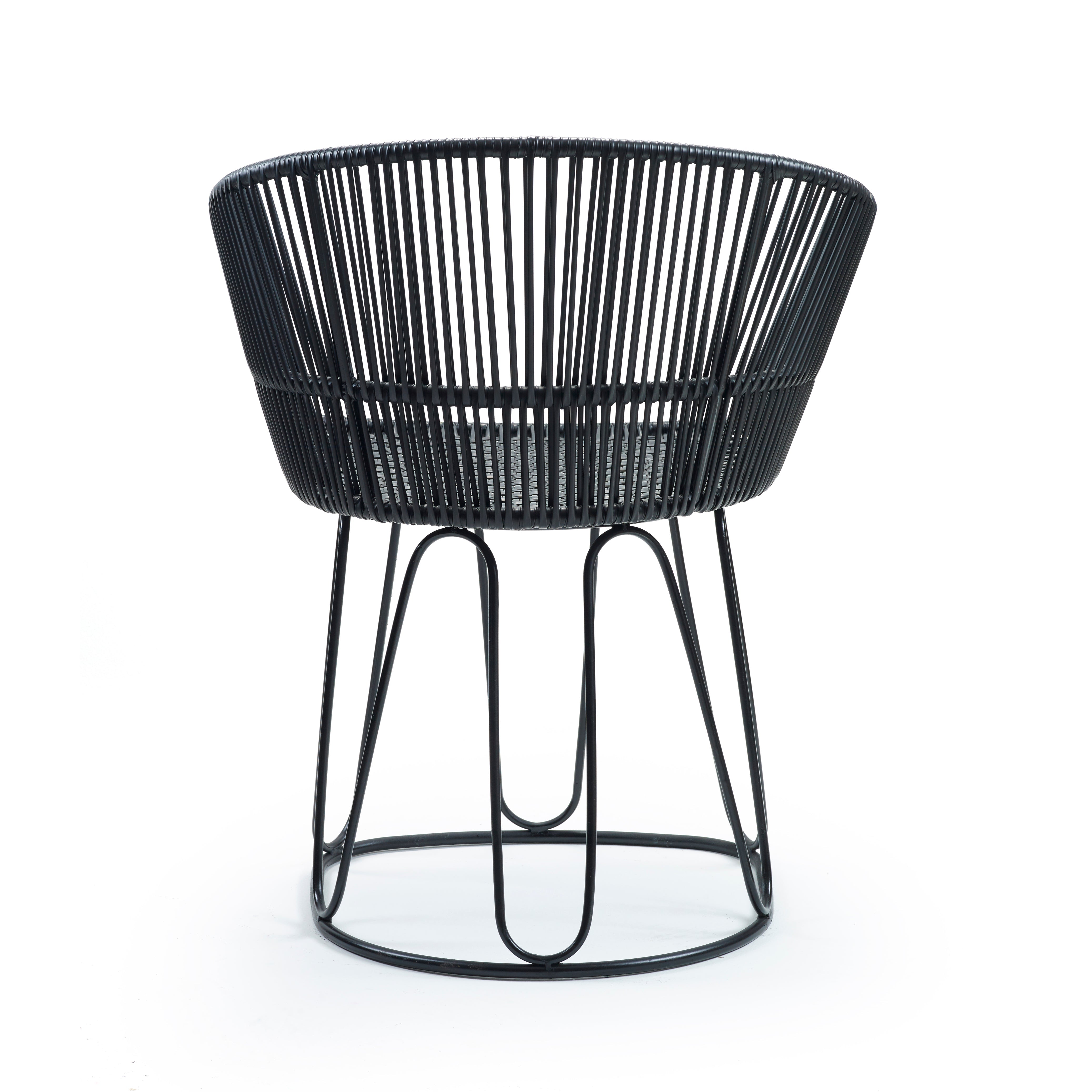 The Circo Chair from Ames features a modern black wire-frame circular design by Sebastian Herkner. Handcrafted in Colombia, its seat and back consist of evenly spaced vertical wires with interconnected legs for stability and a sleek, minimalist look. Now on sale!.