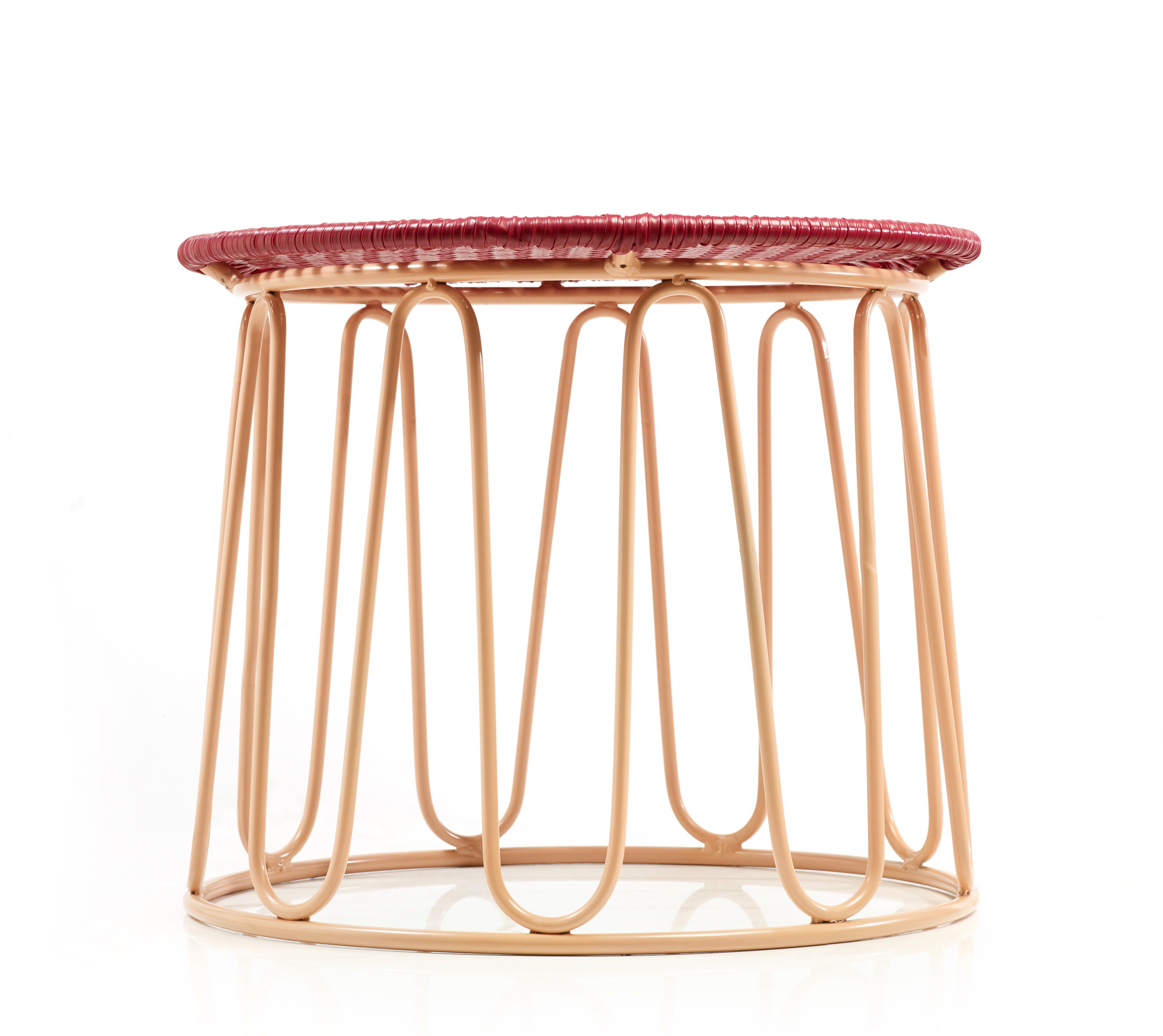 The Ames Circo Side Table by Ames features a light tan metal wire base and a flat, circular maroon woven top, photographed against a white background—handcrafted Colombian furniture designed by Sebastian Herkner.