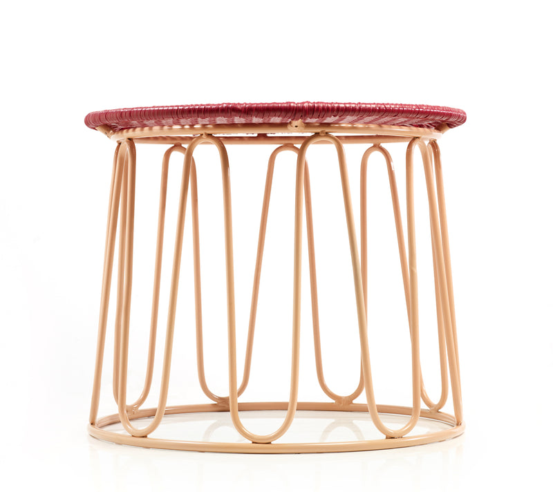 The Ames Circo Side Table by Ames features a light tan metal wire base and a flat, circular maroon woven top, photographed against a white background—handcrafted Colombian furniture designed by Sebastian Herkner.