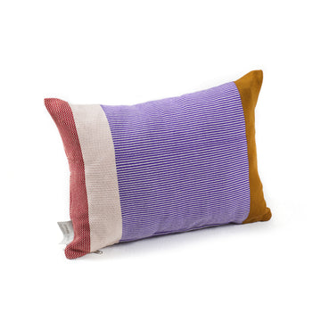 The Maraca Cushion by Ames is crafted from hand-woven cotton with stripes in vibrant purple, red, cream, and mustard yellow. Enhanced with natural dyes for rich colors, it features a small tag on one side.