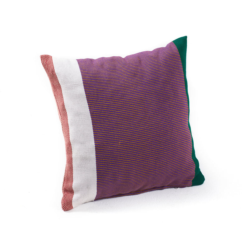 Explore the Maraca Cushion by Ames, a square creation of hand-woven cotton featuring bold red and purple vertical stripes accented with white and dark green edges. Crafted with natural dyes, this striking piece stands out beautifully against a plain white background.