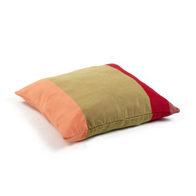 The Maraca Cushion by Ames features a hand-woven cotton square design with vibrant orange, green, and red color blocks, enhanced by natural dyes. It stands out beautifully against a plain white background.