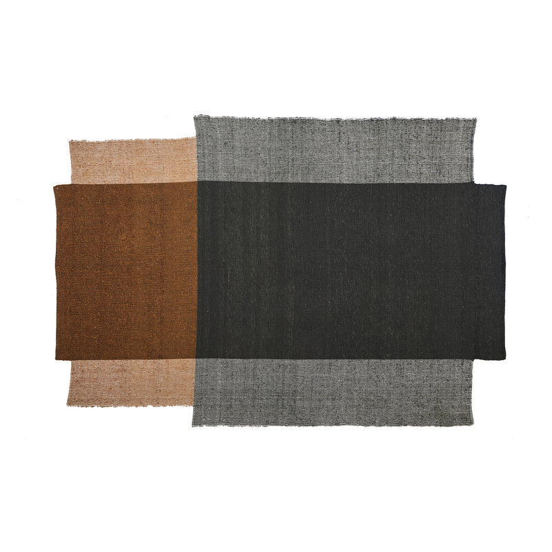 The overlapping brown, black, and gray textures of the Nobsa Rug by Ames evoke artistry akin to hand-woven wool from Nobelian traditions. Its minimalist design mirrors the subtle color transitions typical of Nobsas craftsmanship against a white background.