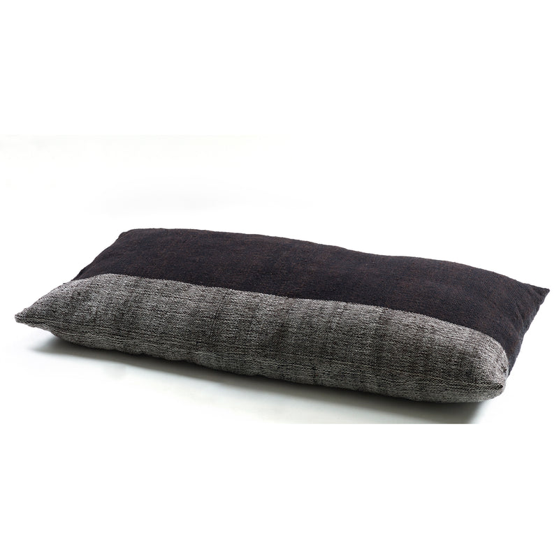 The Ames Nobsa Cushion by Ames, designed by Sebastian Herkner, is a hand-woven rectangular wool pillow with a two-tone dark and light gray design, displayed on a white background. Adds modern elegance to any space.