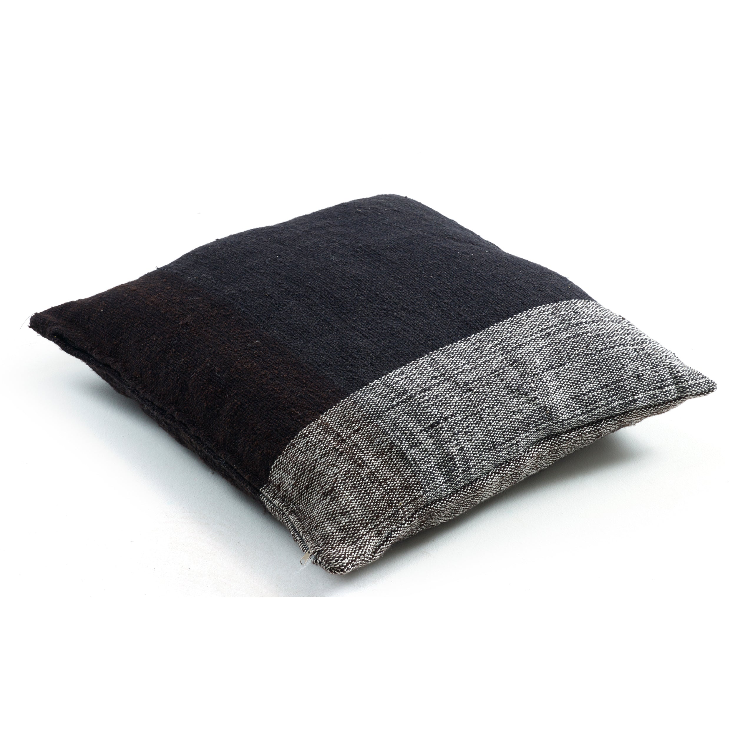 The Ames Nobsa Cushion by Ames is a square, hand-woven wool pillow in textured dark brown with a wide light gray band along one edge, shown on a white background.