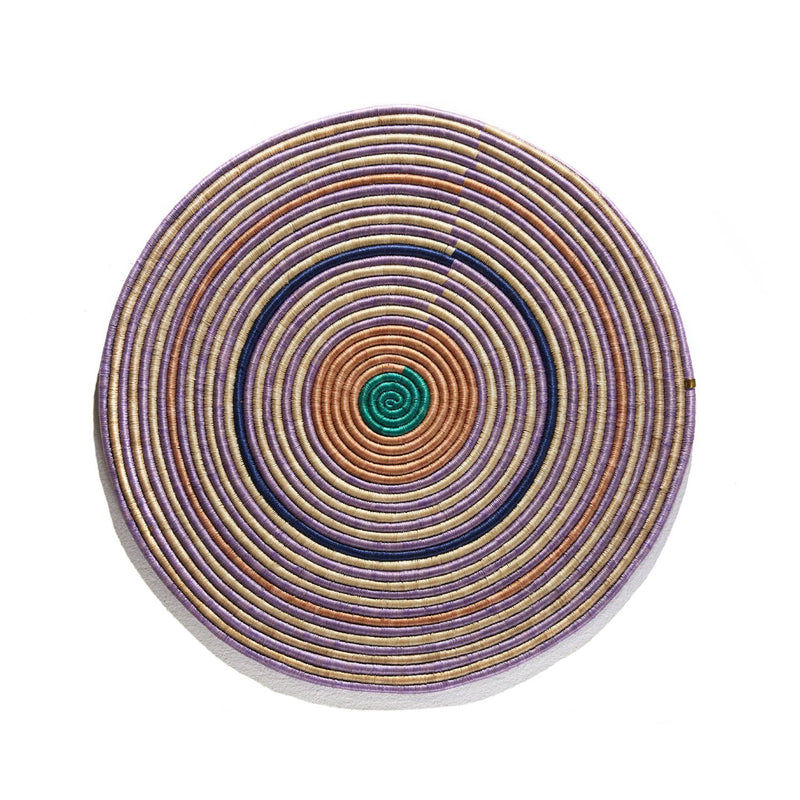 The Ames Ojitos Wall Decoration Andes by Ames is a handcrafted, coiled fique palm fiber accent featuring spiraling beige, purple, orange, and green rings—vibrantly inspired by traditional wall decor.