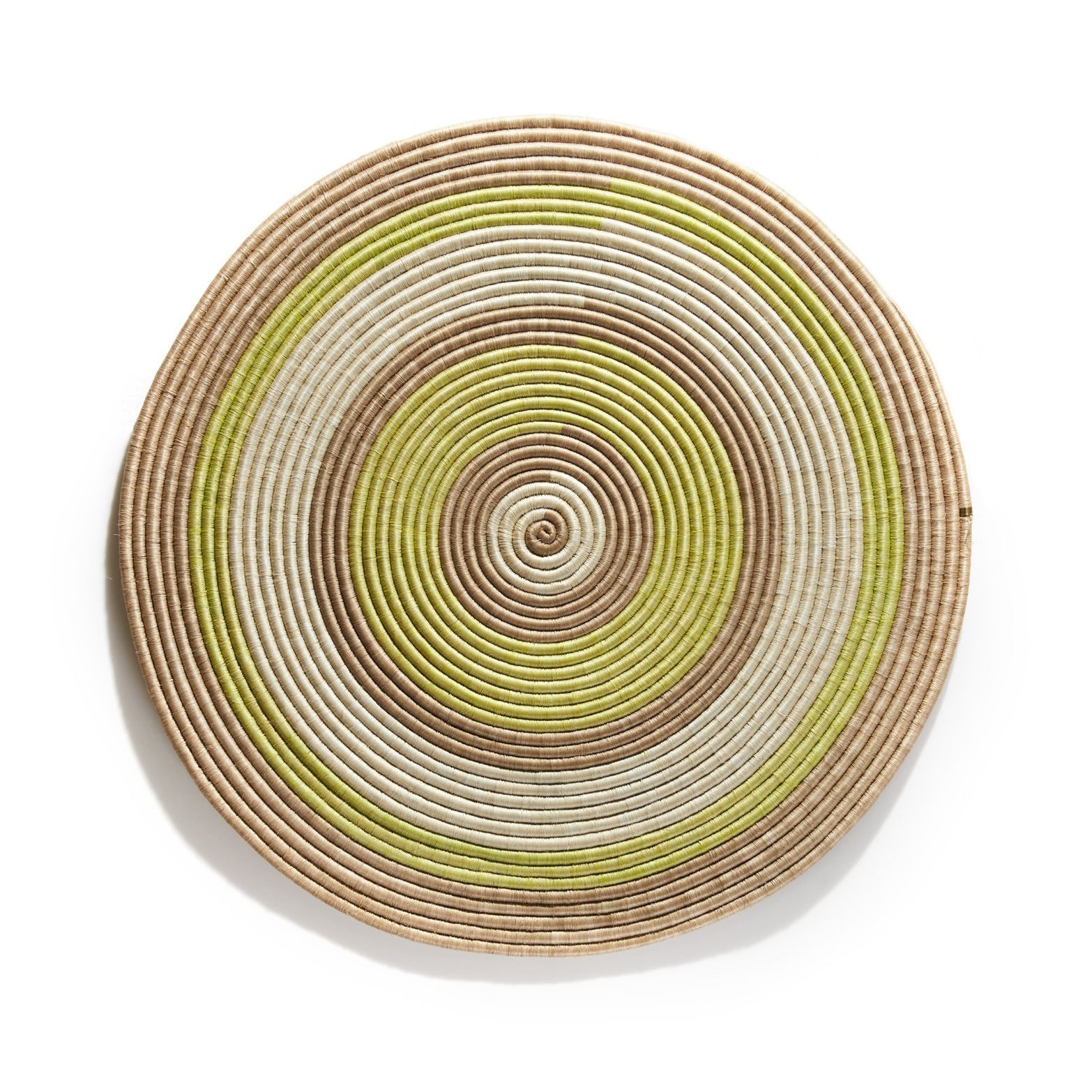 The Ames Ojitos Wall Decoration Andes by Ames is a round, woven basket lid made from fique palm fibers, showcasing concentric rings in beige, brown, white, and light green against a white background.