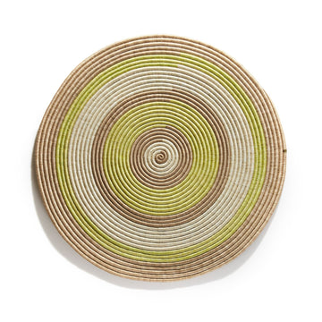 The Ames Ojitos Wall Decoration Andes by Ames is a round, woven basket lid made from fique palm fibers, showcasing concentric rings in beige, brown, white, and light green against a white background.