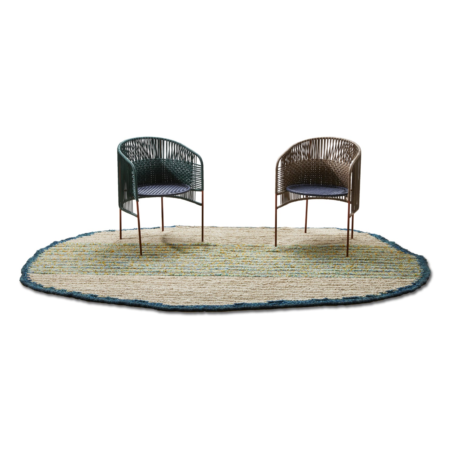 Two woven chairs, one dark green and one brown, are placed on an oval Ames Uilas Rug by Ames featuring blue and cream stripes, set against a plain white background.