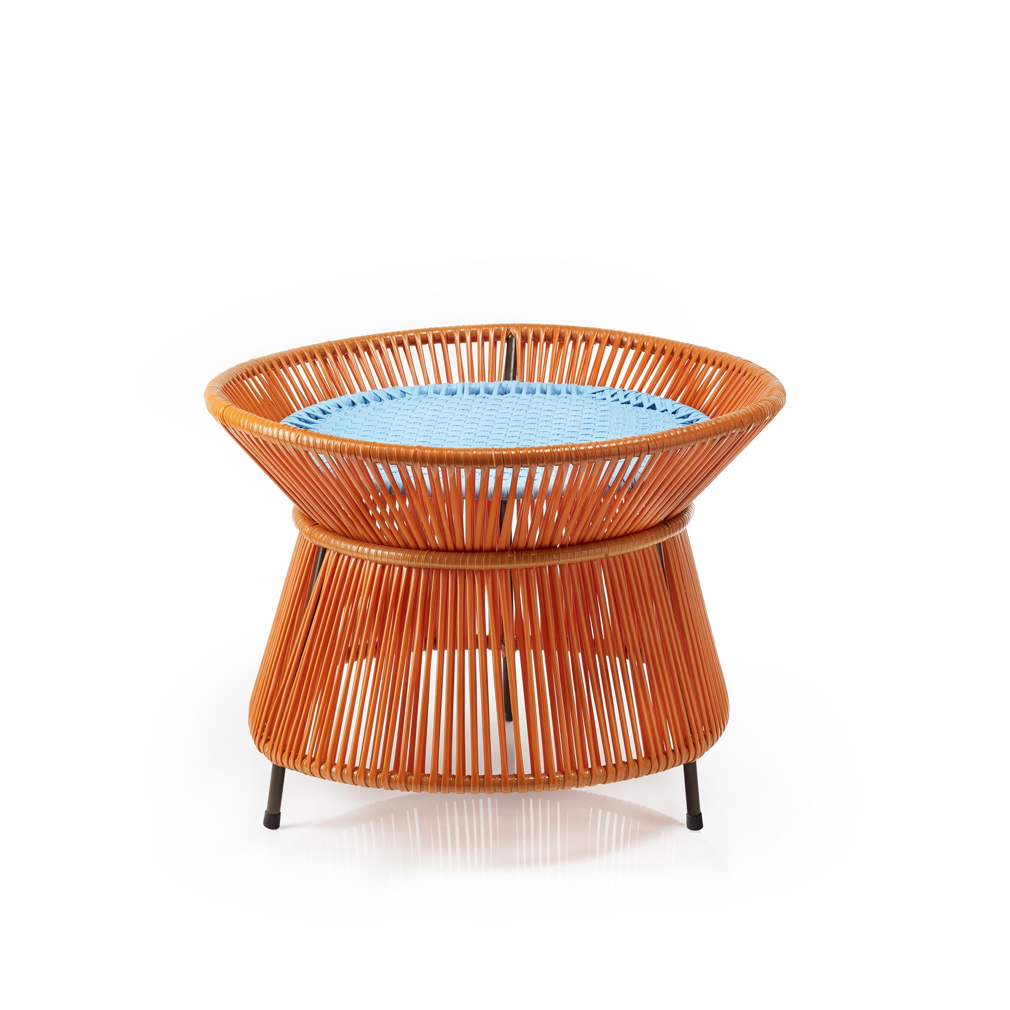 The Caribe Basket Table from Ames features a round, woven design with an orange frame and blue seat, inspired by the Momposino weaving technique. Its flared base and vertical weave rest on small black legs, embodying modern outdoor furnitures vibrant charm.