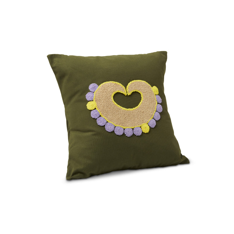 The Nido Piqui pillow by Ames is a square olive-green cushion featuring an embroidered yellow and purple heart with small circular patterns, handcrafted to highlight its exquisite craftsmanship and vibrant design, displayed against a white background.