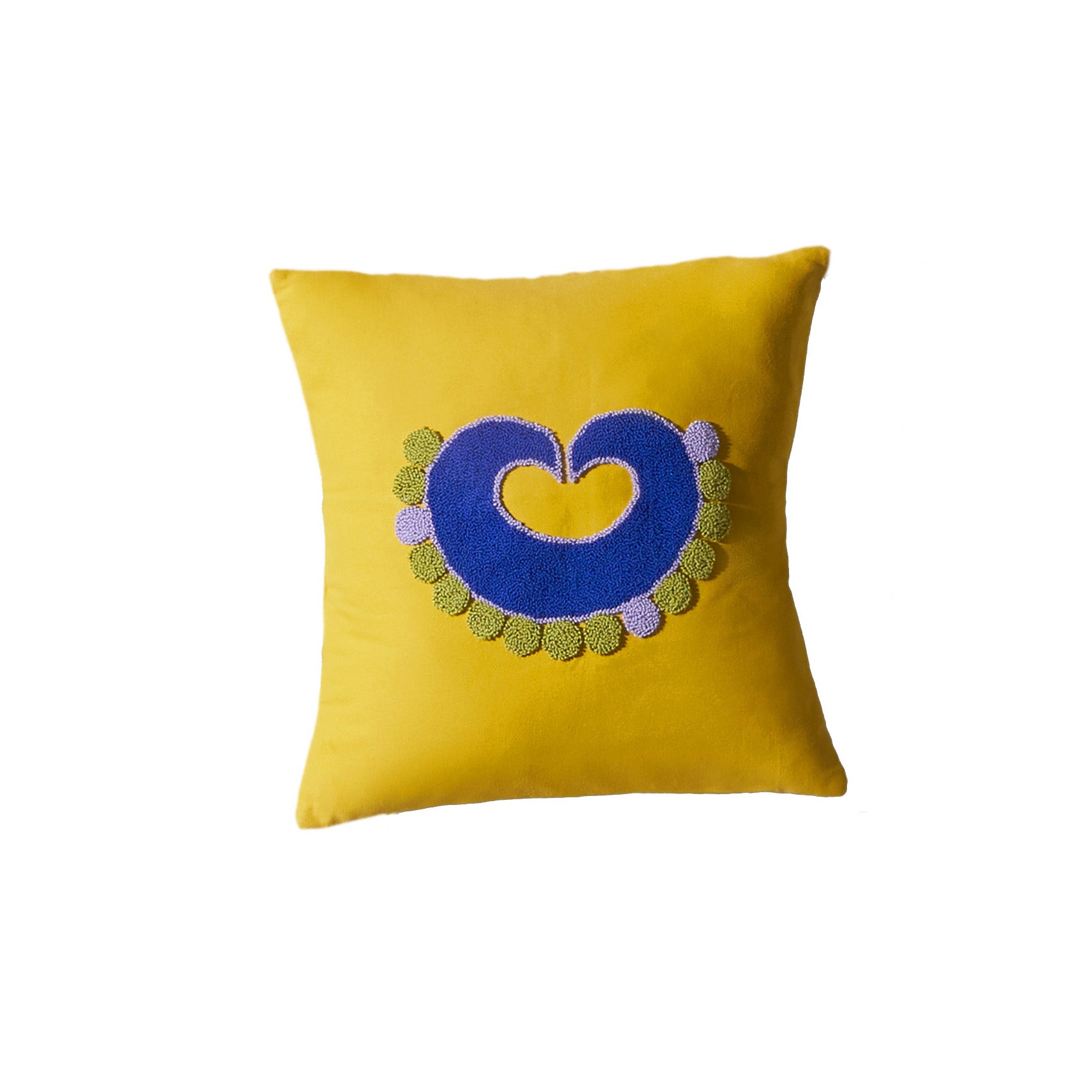 This Nido Piqui pillow by Ames showcases a central blue heart framed by green and purple circles, based on Sebastian Herkners style. Its handmade design makes it a unique addition to any space.