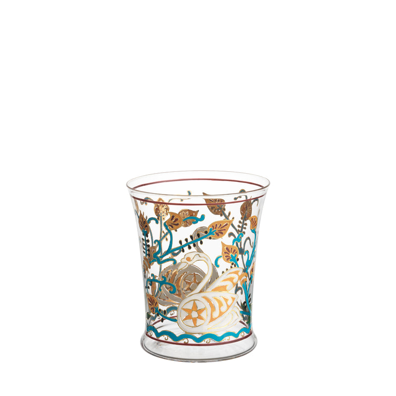 The Alhambra Tumbler by Lobmeyr features intricate hand-painted designs with leaf and seashell motifs in turquoise, gold, and brown. This decorative glass has elegant patterns on a wide rim and a slightly tapered base, echoing the artistic style of the Lobmeyr Alhambra series.