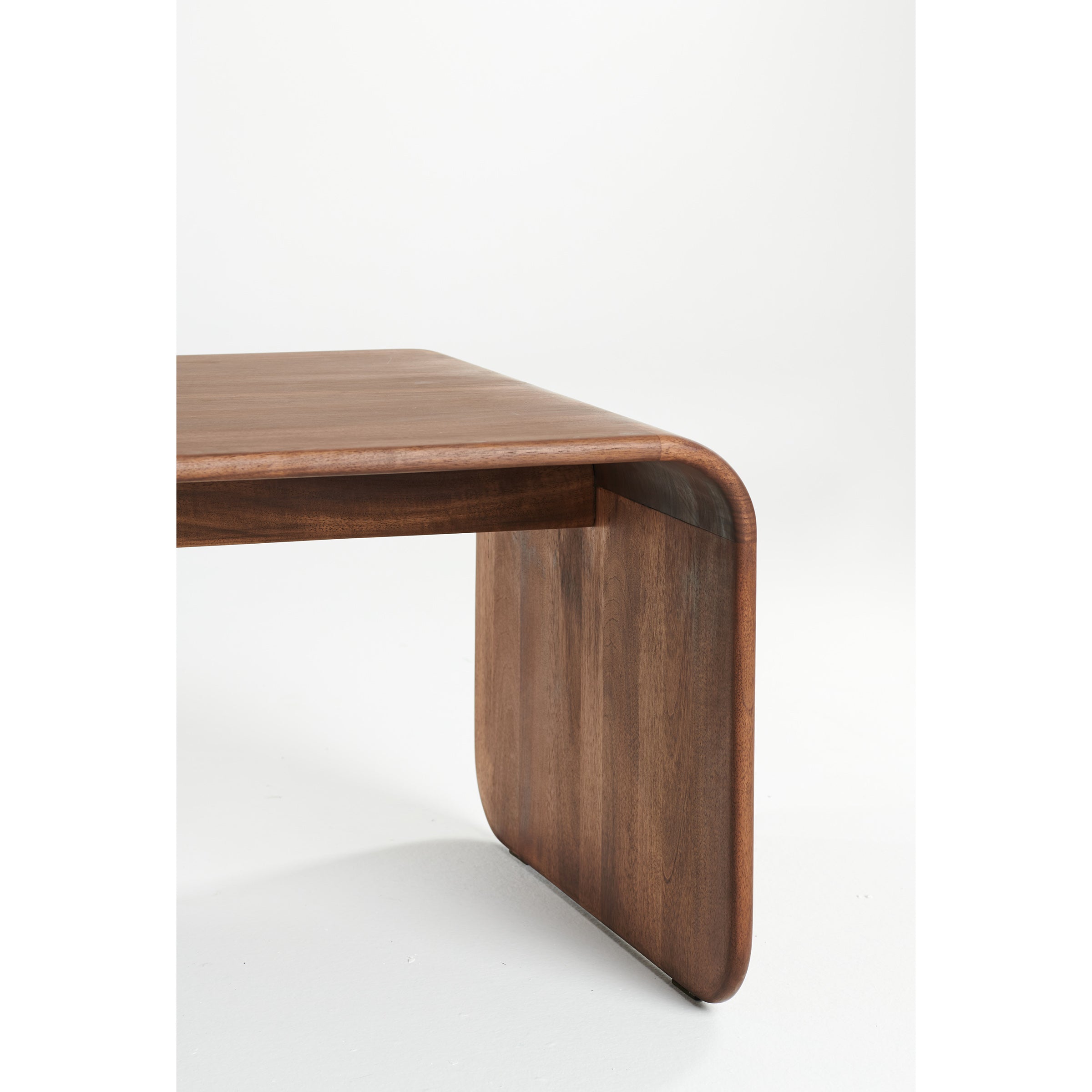 The ENY Coffee Table by Artisan features a smooth, curved wooden corner in a minimalist, modern design. Crafted from solid wood and enhanced with natural oils, it offers an environmentally-friendly and sleek appearance.